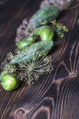 Fresh green cucumber with flowering dill on a wooden background