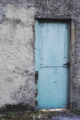 old house concrete wall with blue door