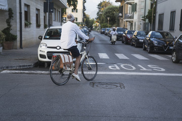 Woman riding bicycle through streets on urban