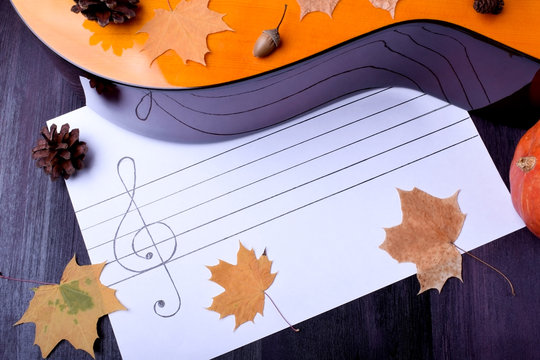 Music autumn composition consisting of guitar, cones, dry leaves and musical staff