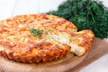 Pie with cheese on a wooden board