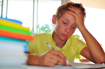 school boy depressed while doing homework
