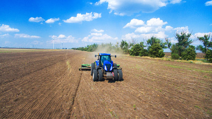 Obraz premium A tractor plowing and sowing in the field
