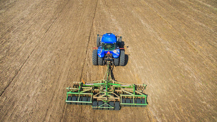 A tractor plowing and sowing in the field