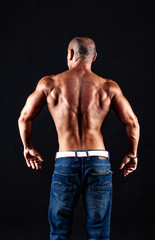 Naklejka na ściany i meble very muscular handsome athletic man on black background