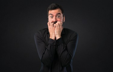 Frightened handsome man with beard on black background