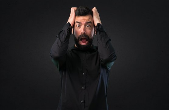 Frustrated handsome man with beard on black background