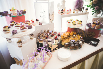 Delicious sweets on wedding candy buffet with desserts, cupcakes