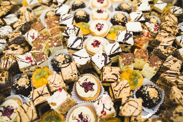 Delicious and tasty dessert table with cupcakes shots at reception closeup