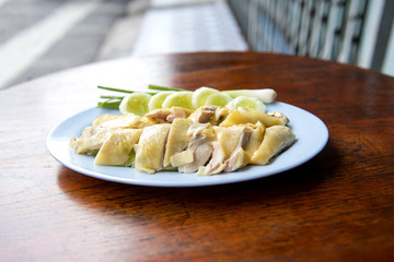 Steamed chicken fillet on a plate with a slice of cucumber to eat a meal with rice and sauce