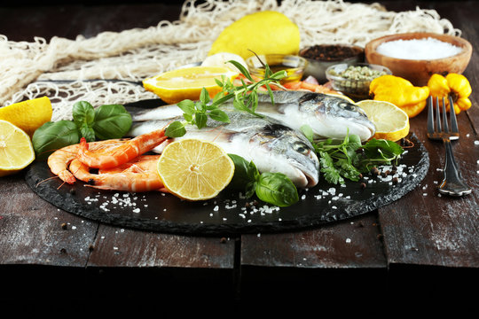 Delicious fresh fish. Fish with aromatic herbs, spices and vegetables - healthy food, diet or cooking concept.