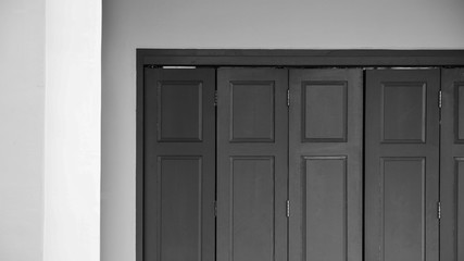 antique wood window at cement building - monochrome