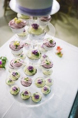 Desserts and wedding cake with very sweet cupcakes at an event.