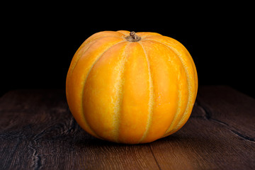 Melon on wooden table on black background