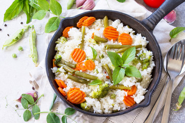Healthy food: Fried rice with vegetables. Prepared and served in a cast-iron frying pan. Diet menu. Copy space.