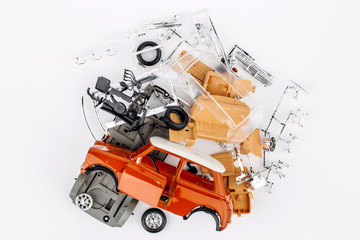 kit for assembling gray plastic car model on white background