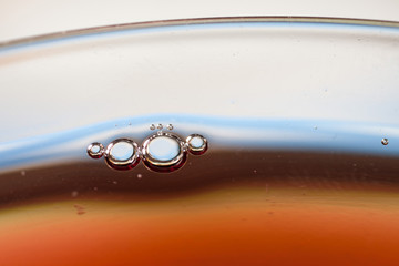 Detail of a glass with red wine and bubbles