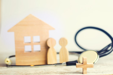 the concept of family medicine and insurance. stethoscope and family on a wooden background