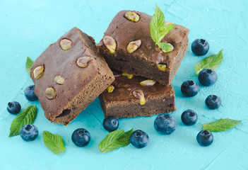 Brownie with blueberries on blue background.