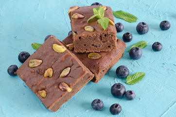 Brownie with blueberries on blue background.