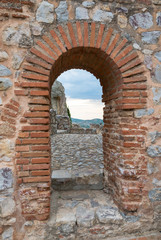 Puerta de piedra natural con vistas a un paisaje medieval