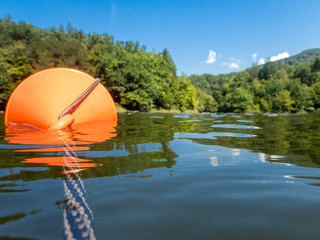 floating buoy in a lake with green hills in the background relaxation concept