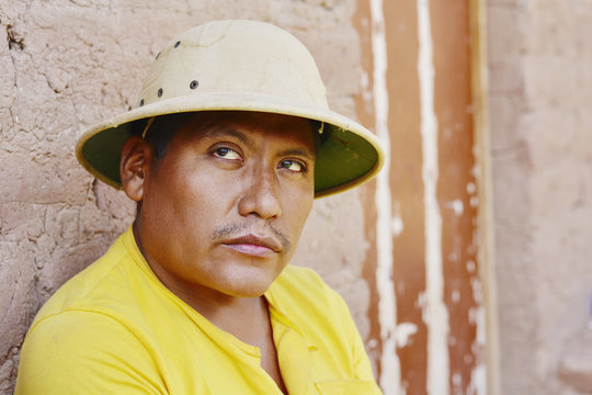Serious native american man wearing hat in the countryside.