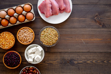 Healthy food. Products rich protein and fiber. Legumes, nuts, low-fat cheese, meet, eggs. Raw beans, chickpeas, lentil, almond, hazelnut on dark wooden background top view copy space