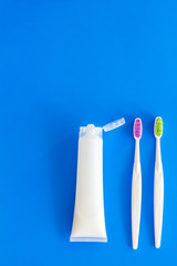 Teeth care, dental care. Toothbrushes and tooth paste on blue background top view space for text