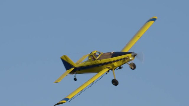 Slow motion close up of crop duster passing over