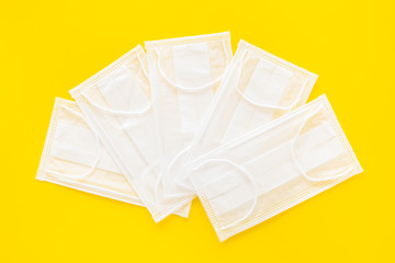 Flu prevention. Medical face masks on yellow background top view mockup