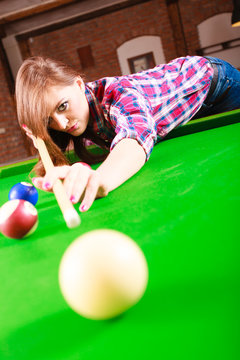 Young woman playing billiard.