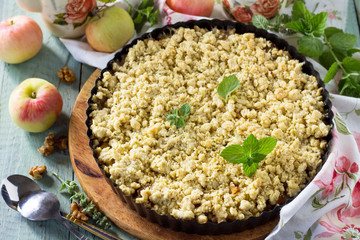Apples crumble, crisp in baking dish on wooden table.
