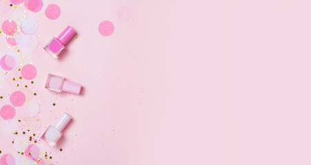 Pastel pink nail polishes and confetti, stars and sparkles. - obrazy, fototapety, plakaty