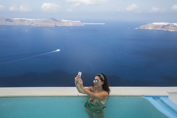 Woman taking a selfie in Santorini Greece.