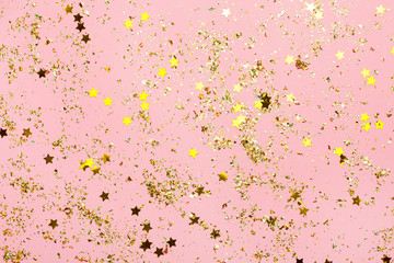 Pink confetti and golden stars and sparkles on pink background.