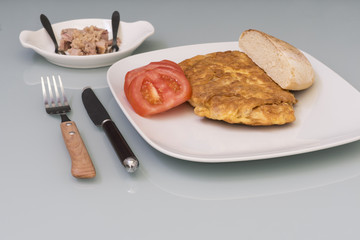 tortilla de atún , rodajas de tomate y pan