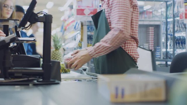 At the Supermarket: Checkout Counter Hands of the Cashier Scans Groceries and Food Items. Clean Modern Shopping Mall with Efficient Queue Management.