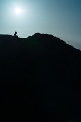 Silhouette of a girl taking a picture on the top of a mountain, Lanzarote, Spain - 219997350