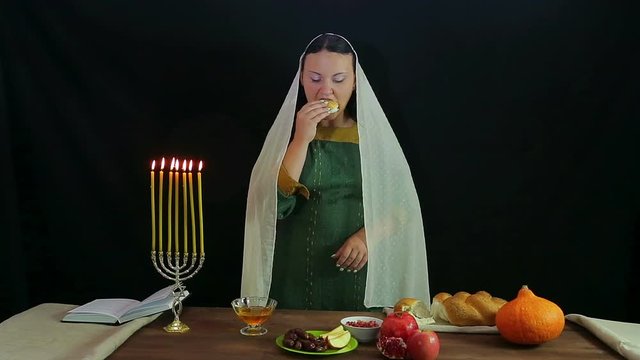 A woman of a Jew takes a piece of a chalice, dips in honey and tries.