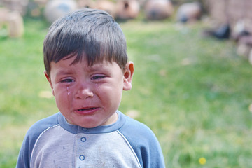 Little latin boy crying in the countryside.
