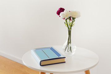 Retro style table with a book and a flower vase