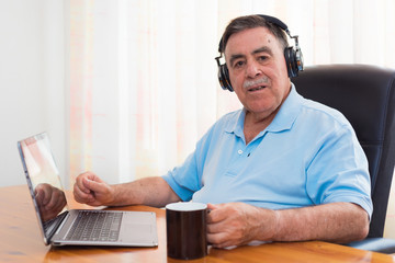 Senior man listening to music with headphones