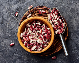 Red beans with white spots on black background. Top view.