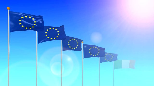 The flag of Ireland is a member of the European Union developing in the wind in the sun with a glare from the lens on a blue background close-up.