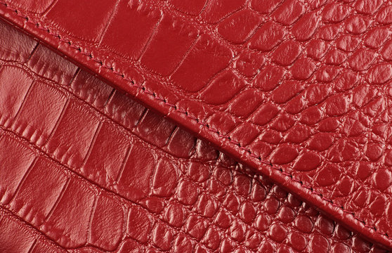 two pieces of genuine red leather with a diagonal seam, like crocodile skin, closeup