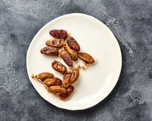 Dried dates fruits on plate with copy space. Top view.