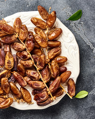 Dried dates fruits on plate with copy space. Top view.