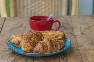 Traditional french breakfast with cup of black coffee and various of croissants