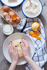 Women's hands kneading dough for baking brioche